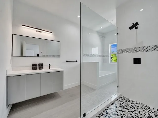 a large white kitchen with kitchen island a sink stainless steel appliances and cabinets