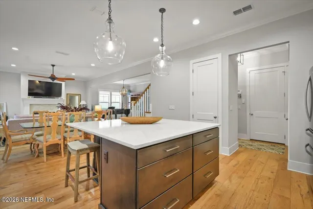 a kitchen with a stove a refrigerator a sink dishwasher with a dining table and chairs with wooden floor