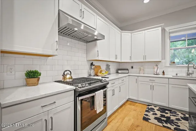 a kitchen with stainless steel appliances a stove a sink and cabinets