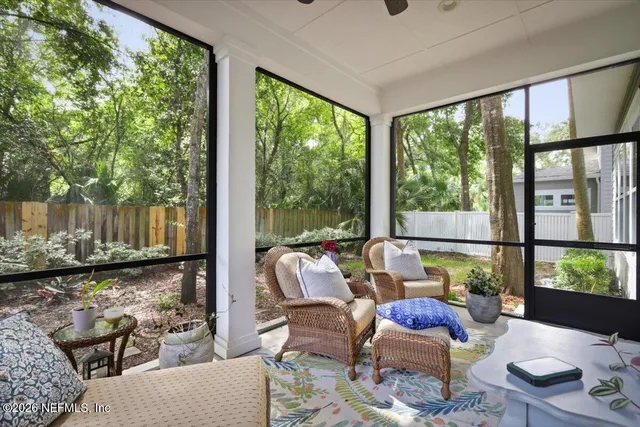 a living room with furniture and floor to ceiling windows