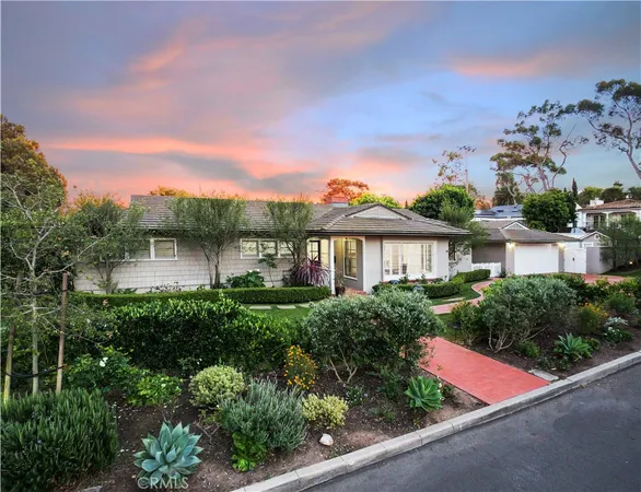 a front view of a house with a yard and potted plants