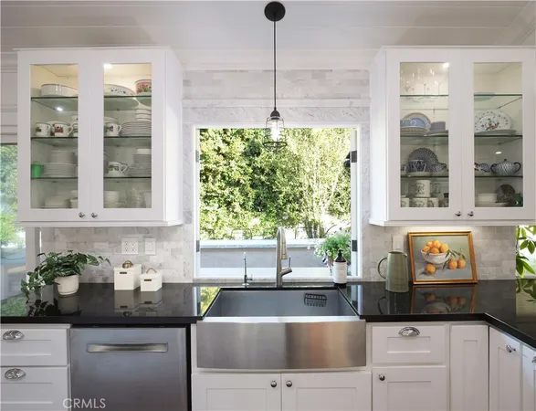 a kitchen with stainless steel appliances granite countertop a sink a counter space and a window