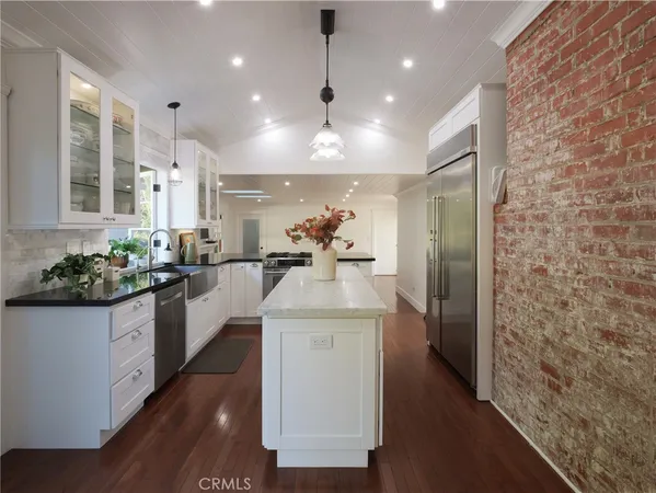 a kitchen with stainless steel appliances kitchen island granite countertop a stove and a refrigerator