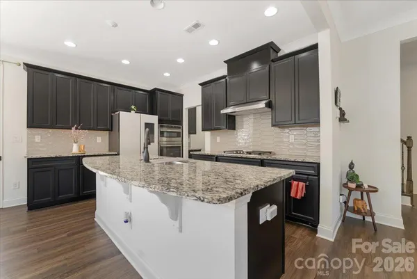 a kitchen with stainless steel appliances granite countertop a sink a stove and a refrigerator