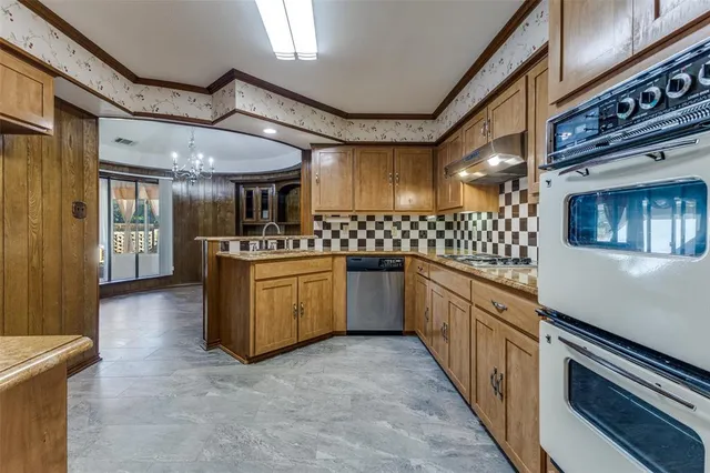 a large kitchen with a sink and stainless steel appliances