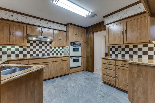 a kitchen with stainless steel appliances a sink and cabinets