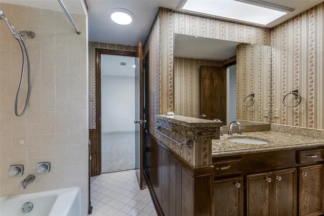 a bathroom with a granite countertop sink and a mirror