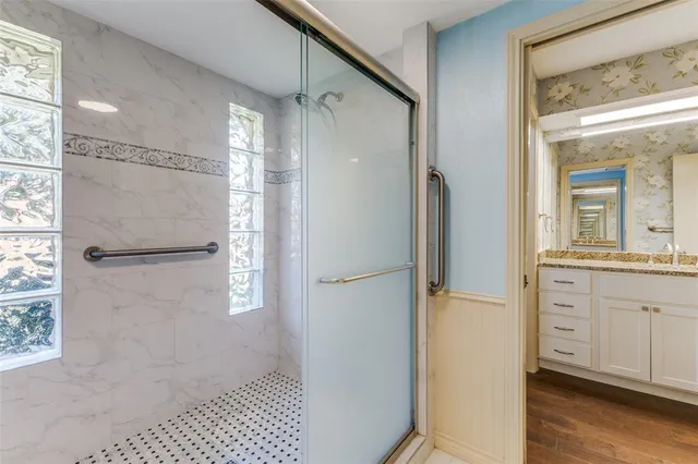 a bathroom with a glass shower door and a sink