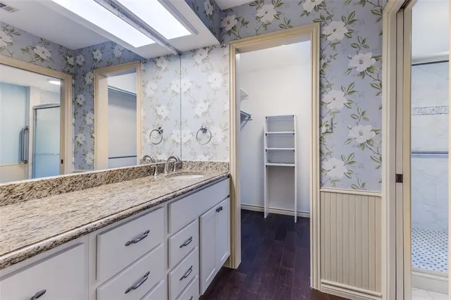 a bathroom with a granite countertop sink and a mirror