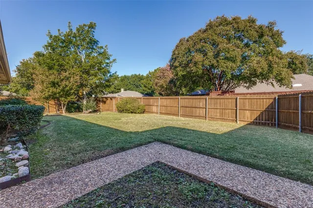 a view of a backyard with wooden fence