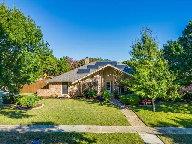a front view of a house with yard and green space