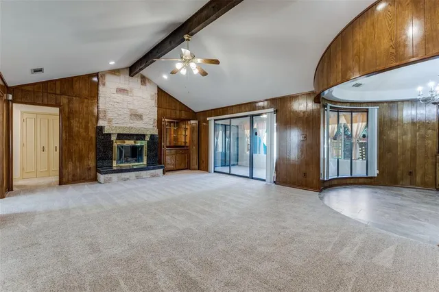 a view of an empty room with a fireplace and a window