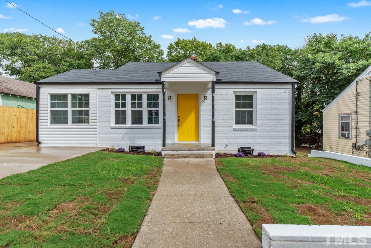 a front view of a house with yard and green space