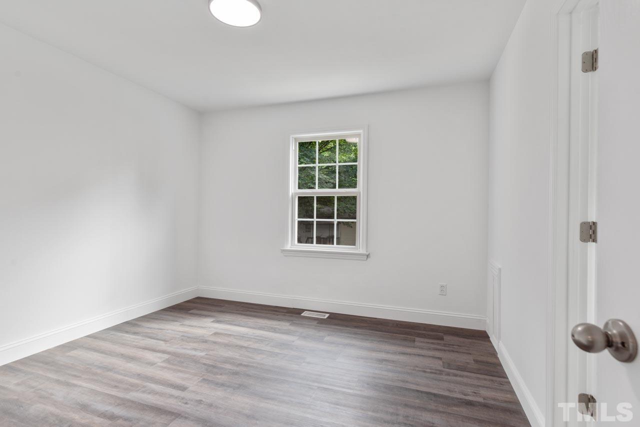 713 Quarry Street Raleigh, NC 27601 - Photo 11 of 26 an empty room with wooden floor and windows