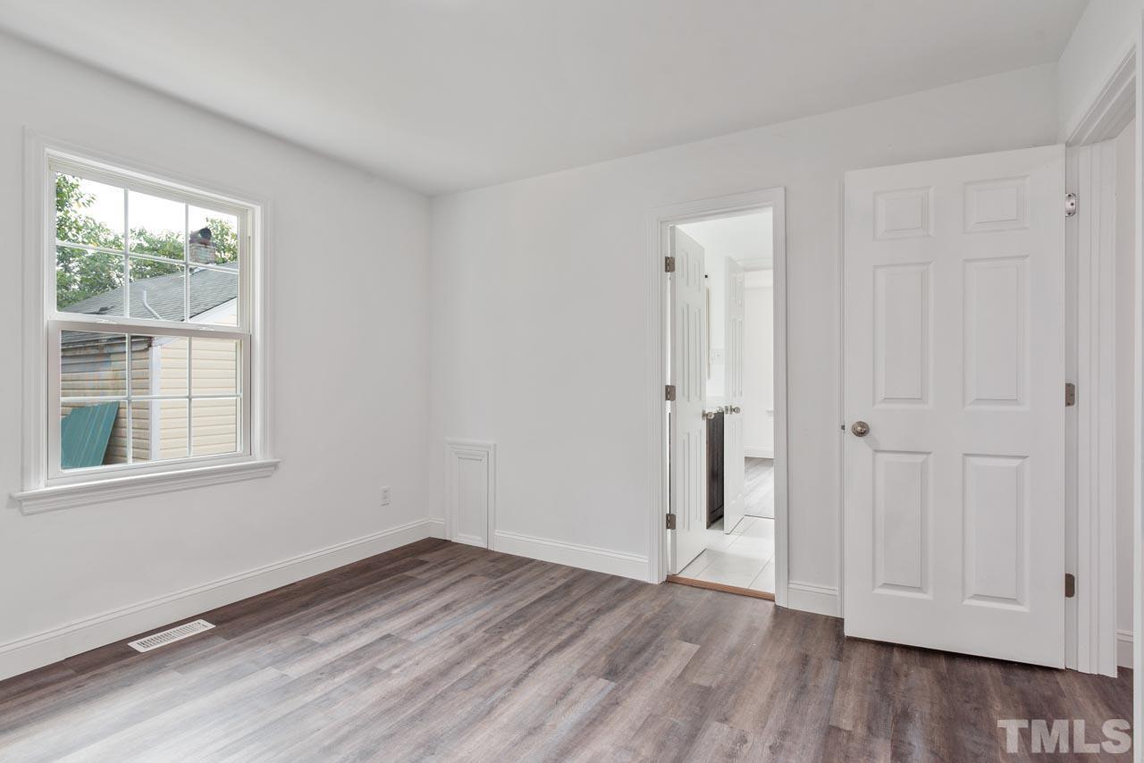 713 Quarry Street Raleigh, NC 27601 - Photo 12 of 26 an empty room with wooden floor and windows