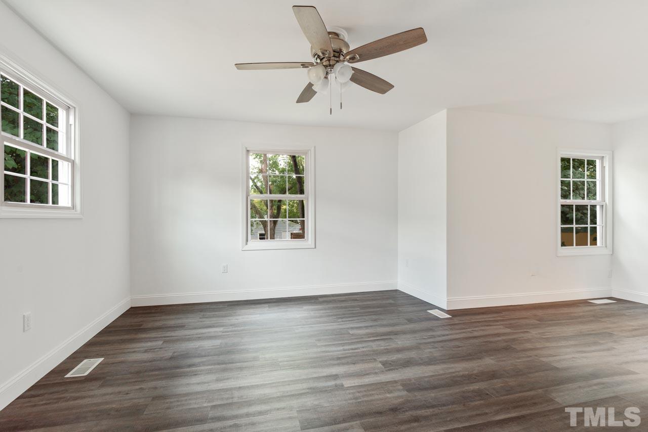 713 Quarry Street Raleigh, NC 27601 - Photo 15 of 26 a view of an empty room with wooden floor and a window
