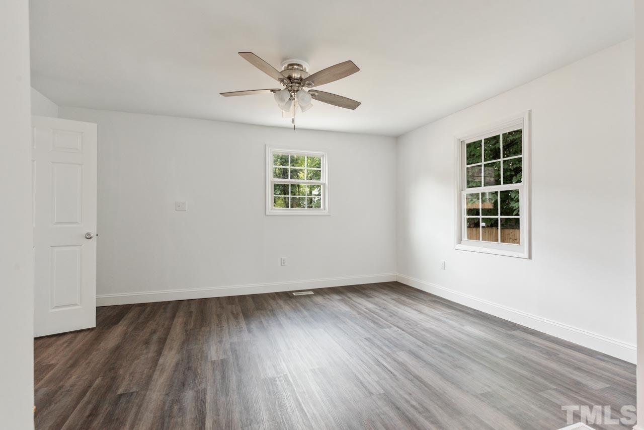 713 Quarry Street Raleigh, NC 27601 - Photo 17 of 26 a view of an empty room with wooden floor and a window