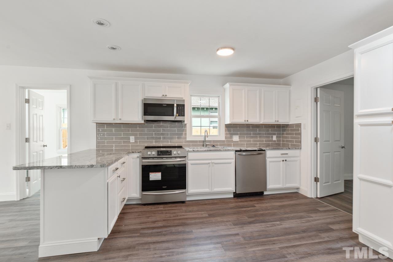 713 Quarry Street Raleigh, NC 27601 - Photo 3 of 26 a kitchen with granite countertop white cabinets and stainless steel appliances