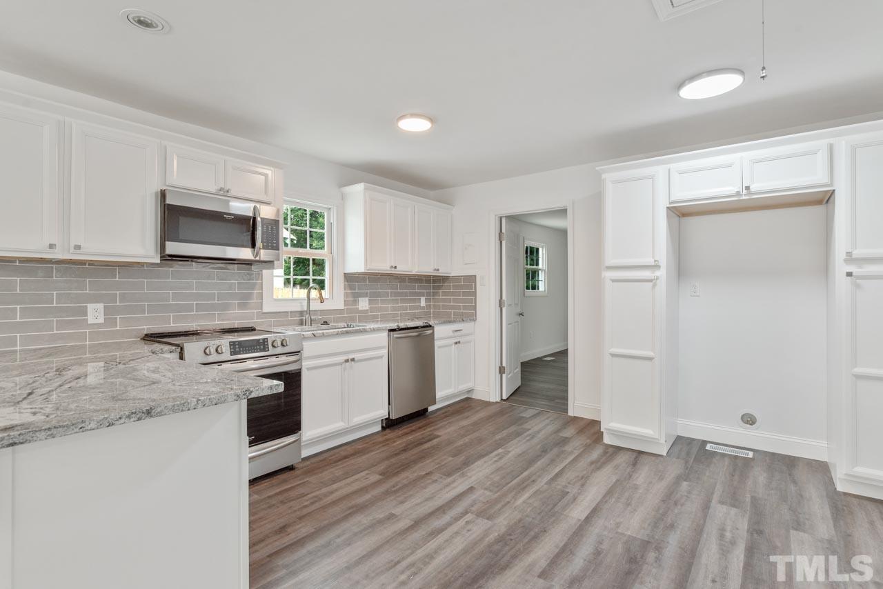 713 Quarry Street Raleigh, NC 27601 - Photo 4 of 26 a kitchen with a stove a sink and a refrigerator