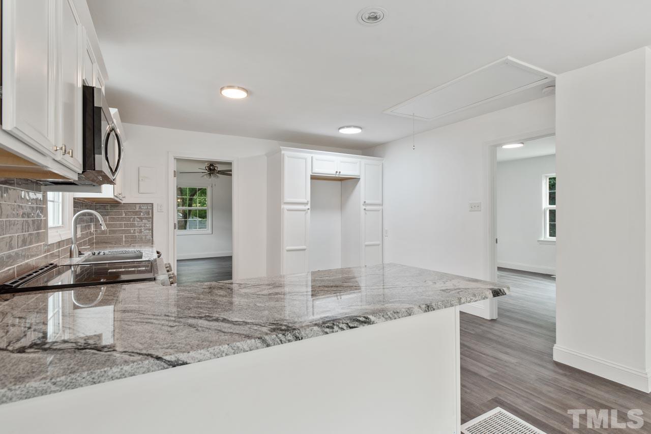 713 Quarry Street Raleigh, NC 27601 - Photo 5 of 26 a kitchen with stainless steel appliances granite countertop a sink and a stove