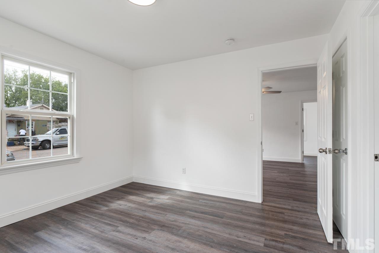 713 Quarry Street Raleigh, NC 27601 - Photo 7 of 26 a view of an empty room with wooden floor and a window
