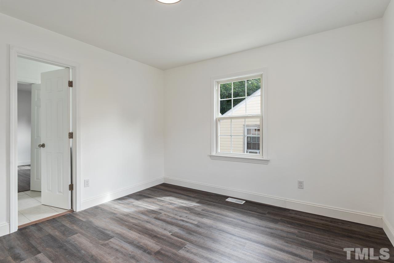 713 Quarry Street Raleigh, NC 27601 - Photo 8 of 26 an empty room with wooden floor and windows