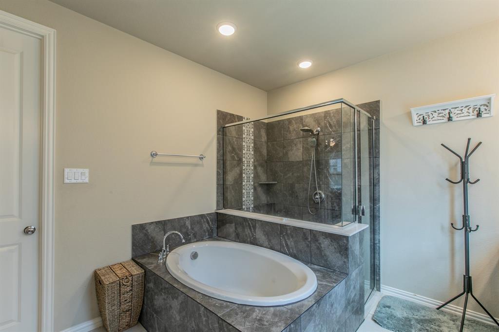 2521 Maidenhair Road Frisco, TX 75033 - Photo 11 of 39 Contemporary bathroom featuring a corner soaking tub and an adjacent glass-enclosed shower