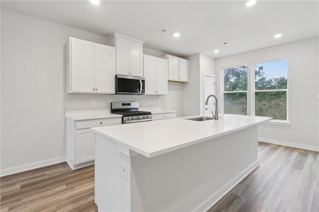 145 River Rdg Drive Moon Township, PA 15108 - Photo 10 of 23 a kitchen with kitchen island a sink a stove a microwave and wooden cabinets
