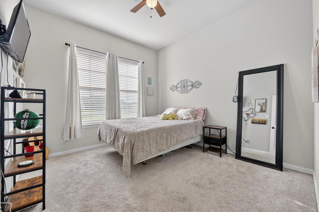 150 Chester Road Springtown, TX 76082 - Photo 15 of 40 a bedroom with a bed and a chandelier