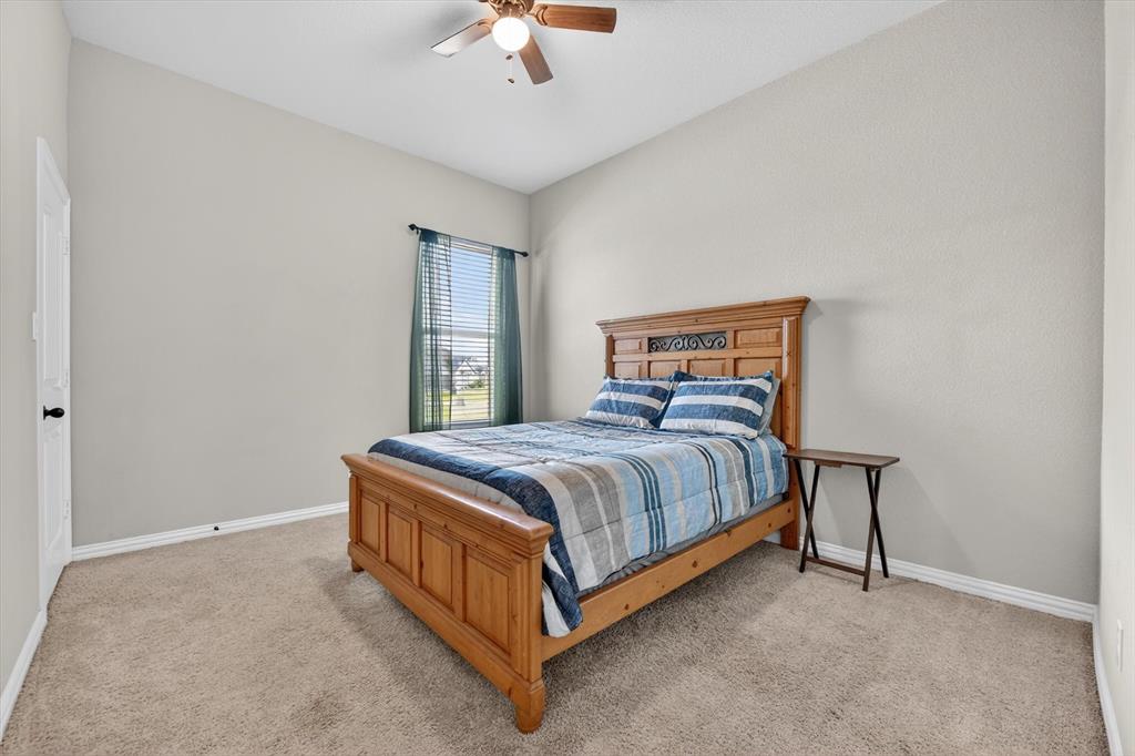 150 Chester Road Springtown, TX 76082 - Photo 24 of 40 a spacious bedroom with a bed and a chandelier