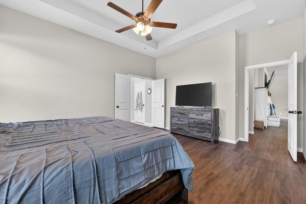 150 Chester Road Springtown, TX 76082 - Photo 29 of 40 a bedroom with a bed and a flat tv screen on wall