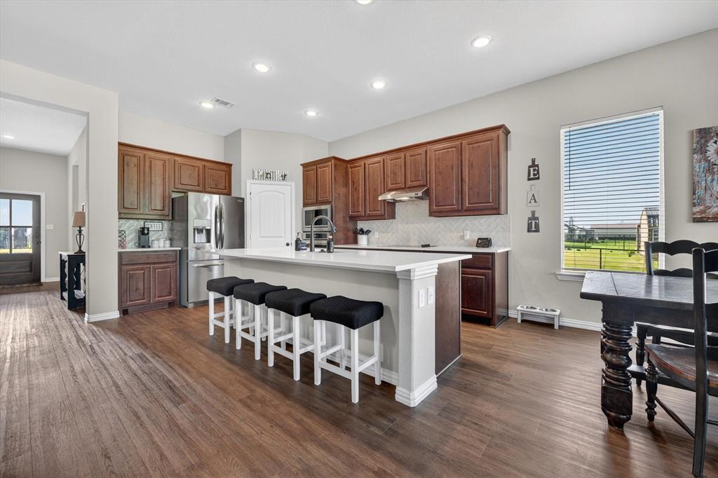 150 Chester Road Springtown, TX 76082 - Photo 9 of 40 a kitchen with stainless steel appliances kitchen island wooden floors and refrigerator