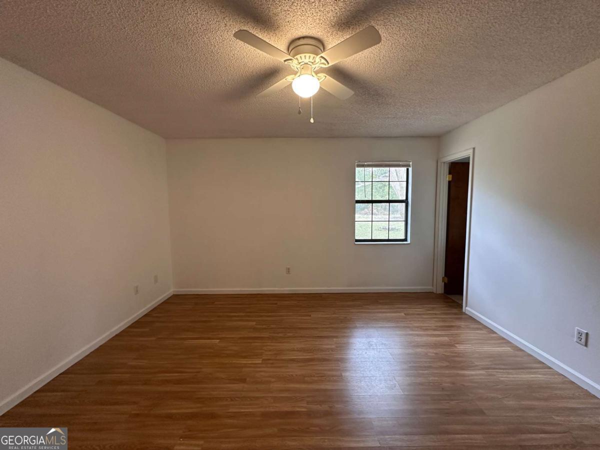 562 Mush Bluff Road St. Marys, GA 31558 - Photo 15 of 22 an empty room with wooden floor and windows