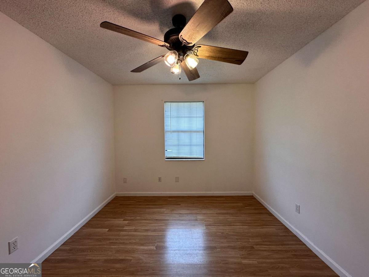 562 Mush Bluff Road St. Marys, GA 31558 - Photo 18 of 22 an empty room with wooden floor and windows