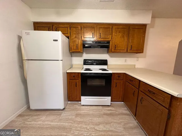 a kitchen with granite countertop a refrigerator stove and microwave