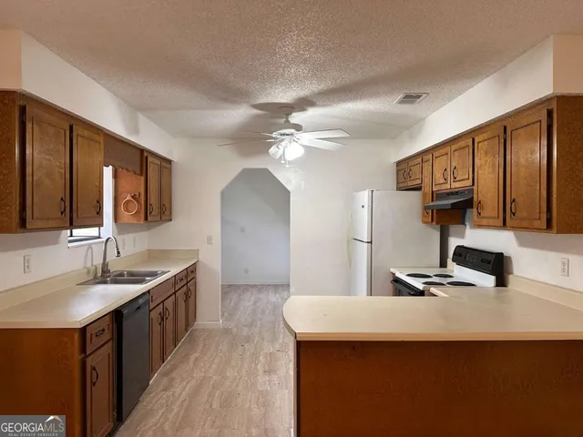 a kitchen with stainless steel appliances kitchen island granite countertop a sink and cabinets