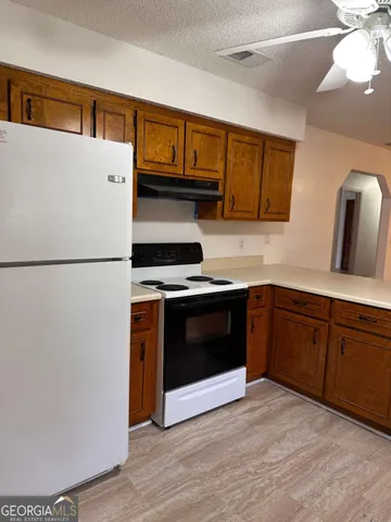 a kitchen with stainless steel appliances granite countertop a refrigerator a stove a sink and a microwave