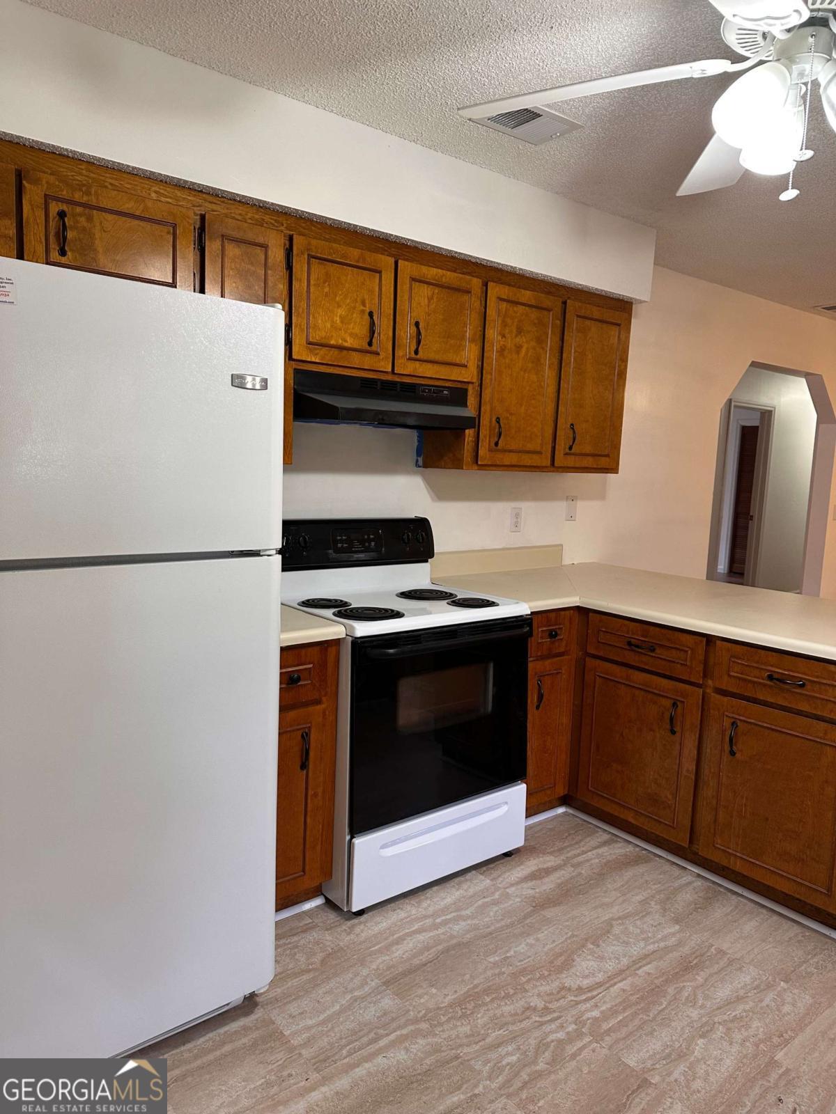 562 Mush Bluff Road St. Marys, GA 31558 - Photo 6 of 22 a kitchen with stainless steel appliances granite countertop a refrigerator a stove a sink and a microwave