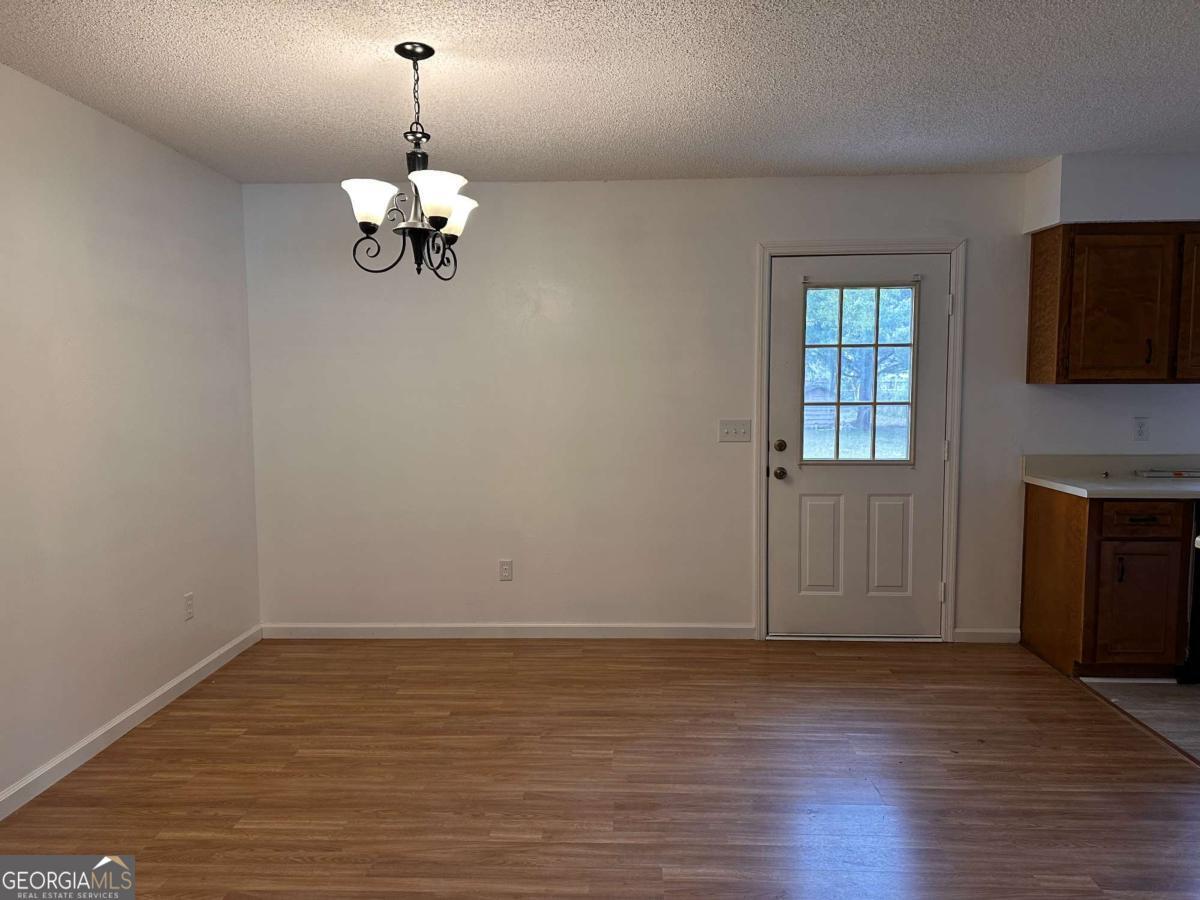 562 Mush Bluff Road St. Marys, GA 31558 - Photo 7 of 22 wooden floor in an empty room with a window