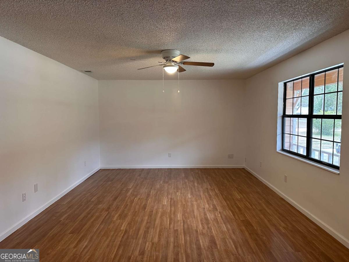 562 Mush Bluff Road St. Marys, GA 31558 - Photo 10 of 22 wooden floor in an empty room with a window