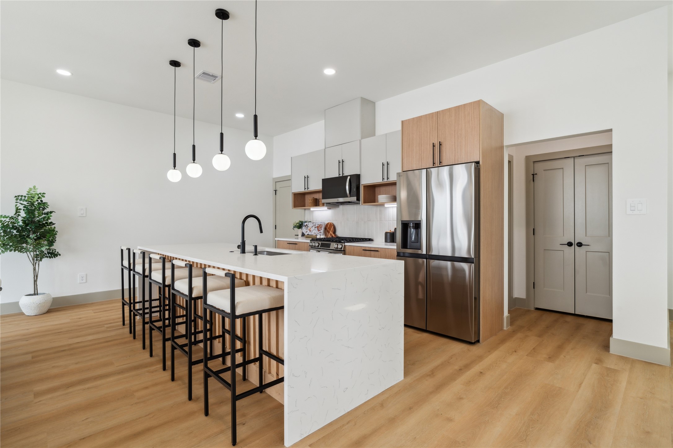 2943 Delafield Street Houston, TX 77023 - Photo 16 of 41 A showcase of refined craftsmanship, the waterfall-edge island features soft veining and fluted wood accents, balancing elegance with texture.