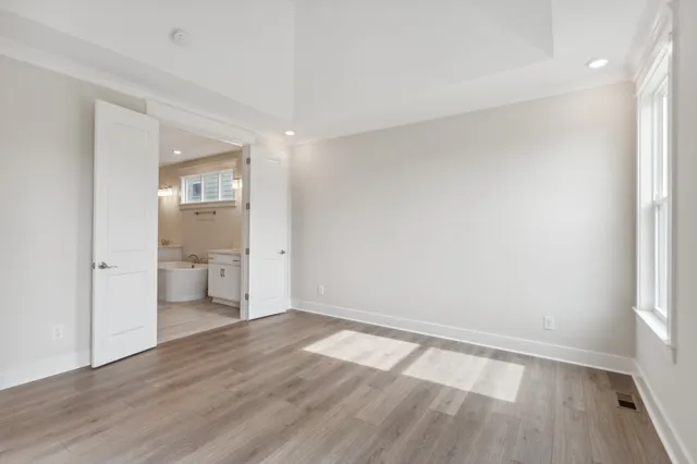 a view of a room with wooden floor and a bathroom