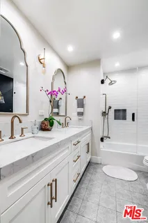 a spacious bathroom with a double vanity sink a mirror and a bathtub