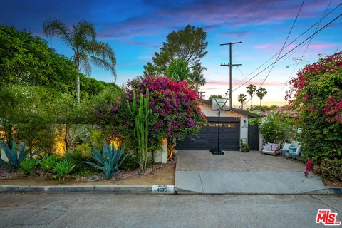 a view of a house with a yard and potted plants