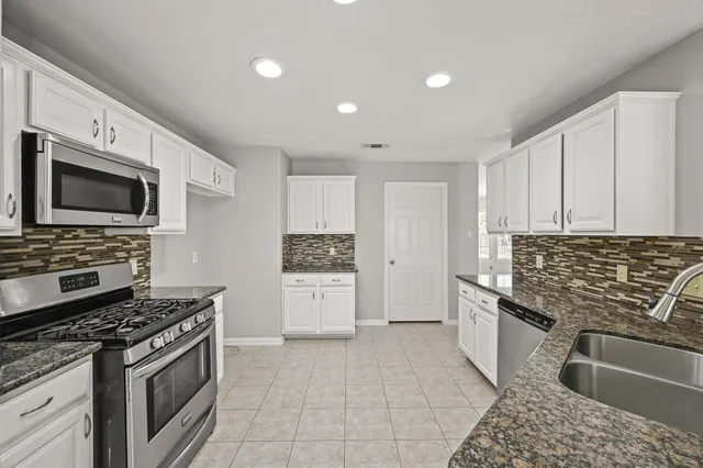 a kitchen with stainless steel appliances granite countertop a sink and cabinets