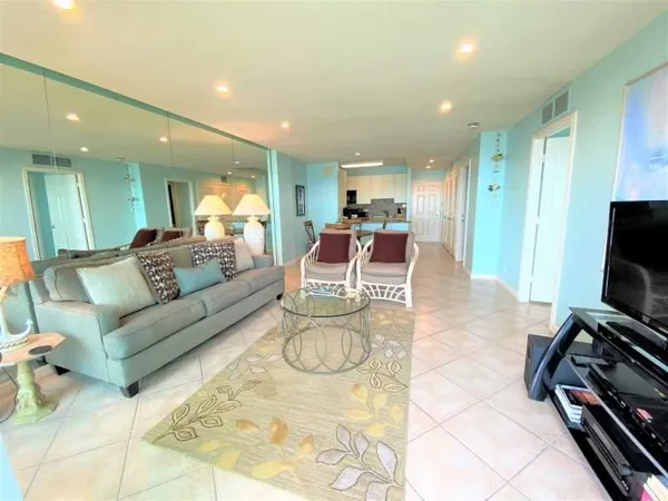 a living room with furniture a flat screen tv and a large window