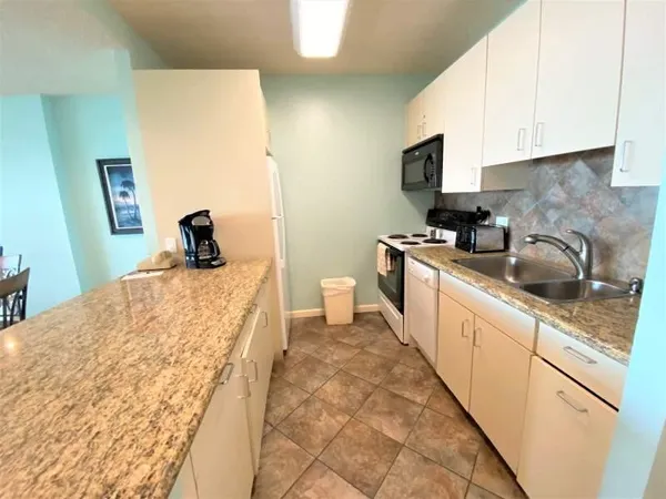 a kitchen with a sink a stove and cabinets