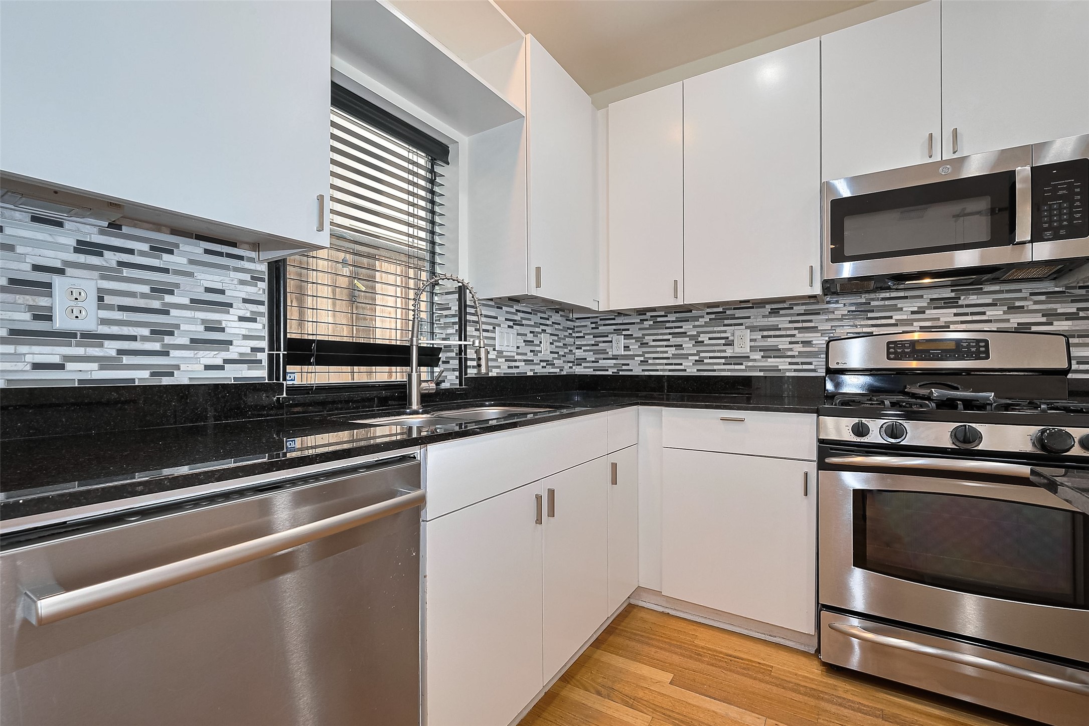 4331 Eigel Street Houston, TX 77007 - Photo 19 of 38 a kitchen with granite countertop a sink cabinets and stainless steel appliances