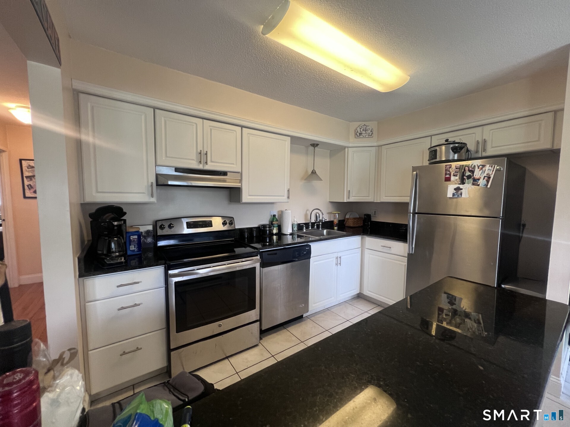 93 Kent Court, Unit 93 Meriden, CT 06450 - Photo 24 of 27 a kitchen with a refrigerator stove and white cabinets