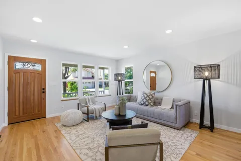 a living room with furniture and a wooden floor
